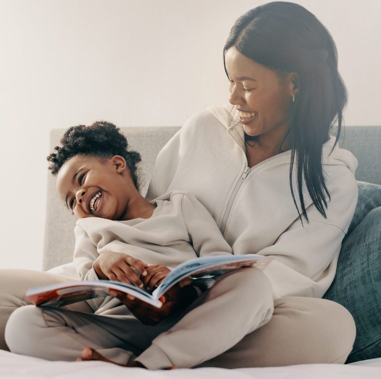 mother reading book to daughter