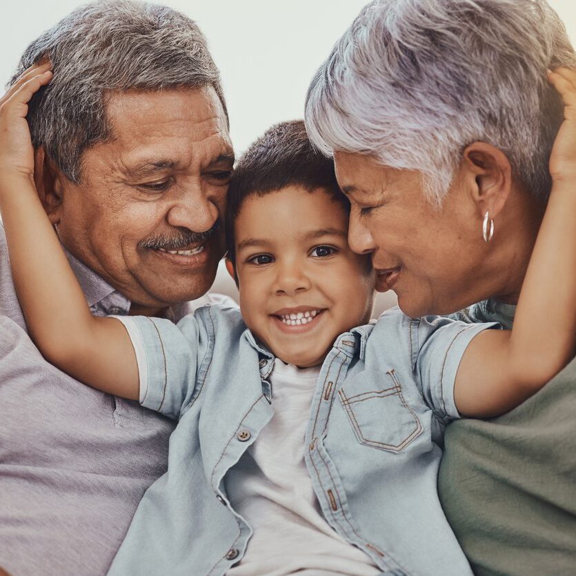 grandparents embracing their grandchild